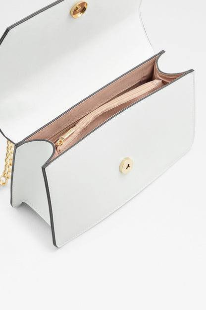 White handbag interior view with tan lining and gold chain strap hardware