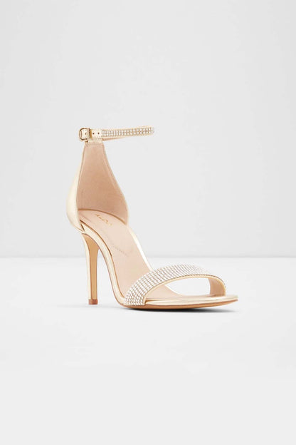 Gold heeled sandal with open toe, rhinestone ankle strap, and stiletto heel.