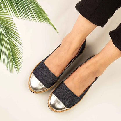 Blue denim slip-on flats with silver toe caps and tan stitched edge