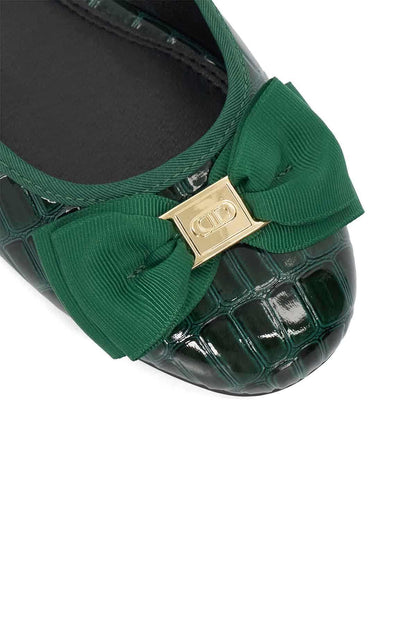 Green ballet flats with bow and gold-tone logo plate, close-up detail.