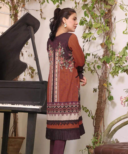 Embroidered tunic dress back with long sleeves, vertical floral motif, and tassel hem