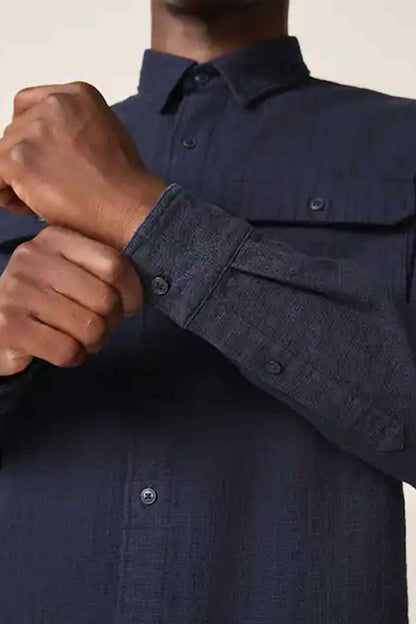 Dark blue button-up shirt close-up of cuff buttons and sleeve placket