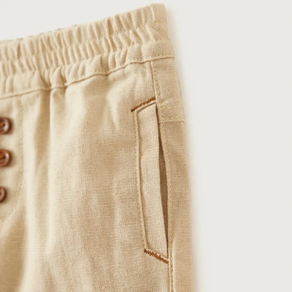 Beige baby trousers detail: elastic waistband and side seam pocket with contrast trim