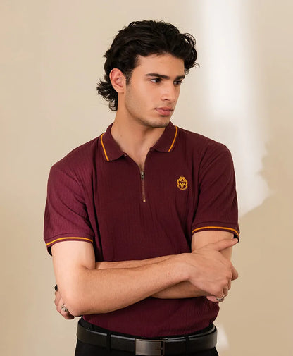 Maroon fitted polo shirt with yellow-trim collar, short sleeves, and chest crest