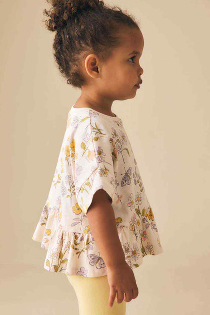 Girls' floral peplum top, side view with short sleeves and gathered waist