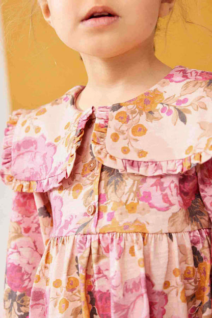 Girls pink floral dress close-up: ruffled neckline and buttoned front bodice