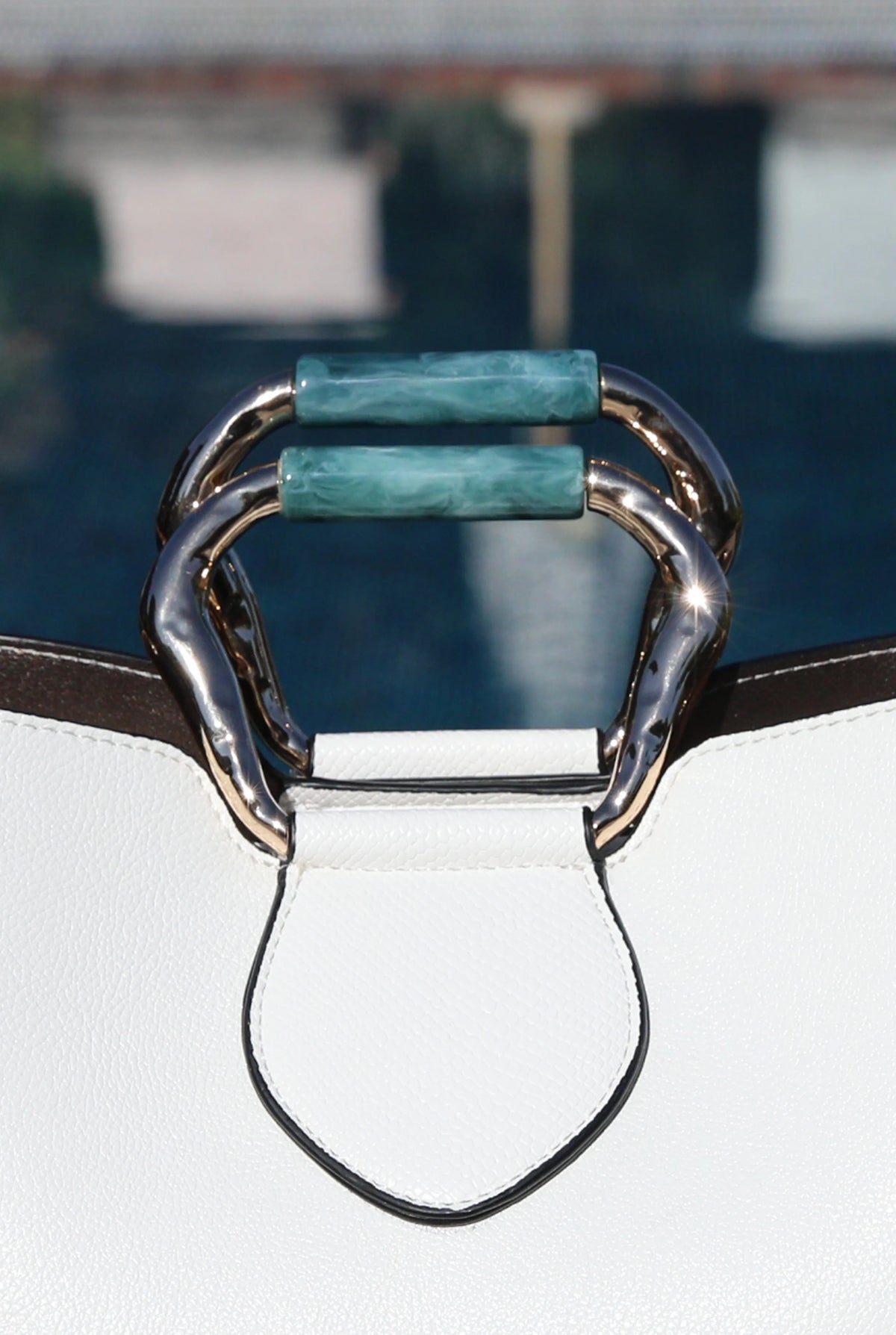 White handbag with green accent handle hardware and gold-tone metal ring
