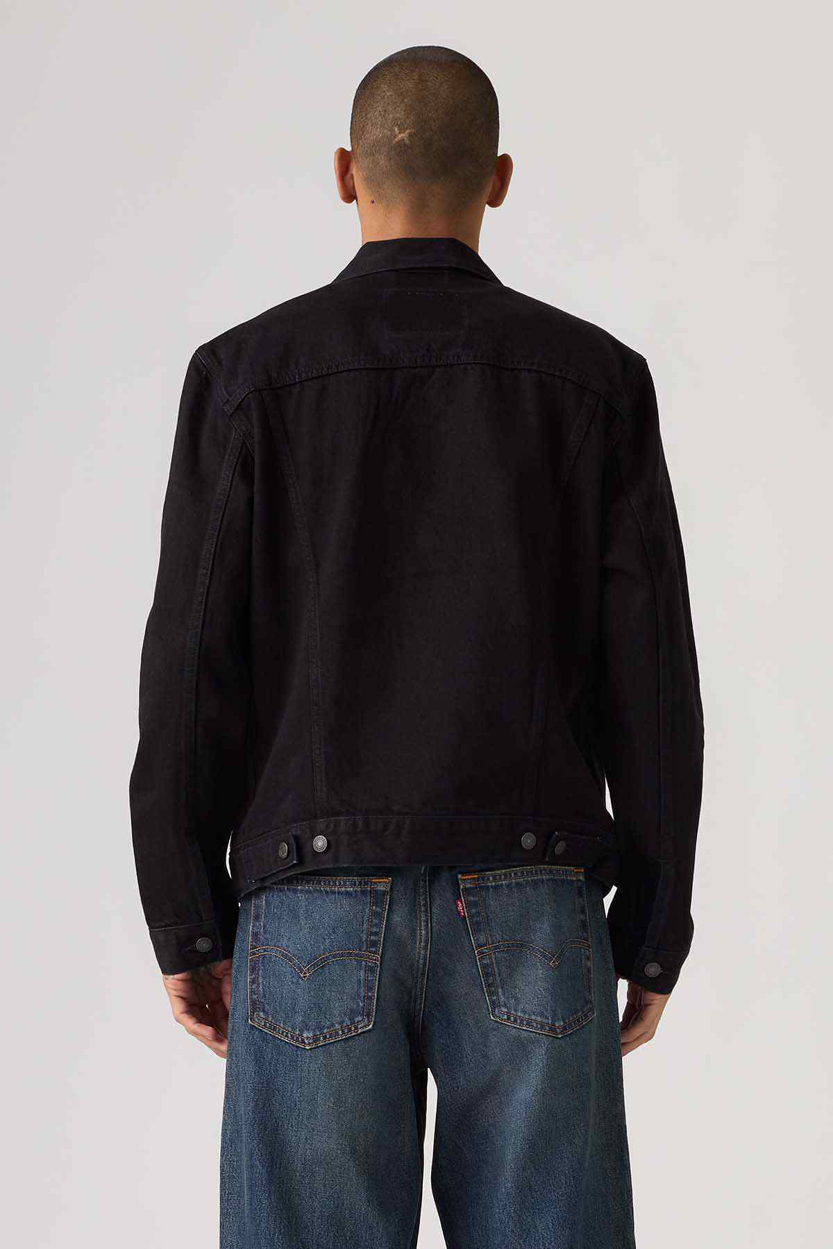 Black denim jacket back view with button closure and flap pockets