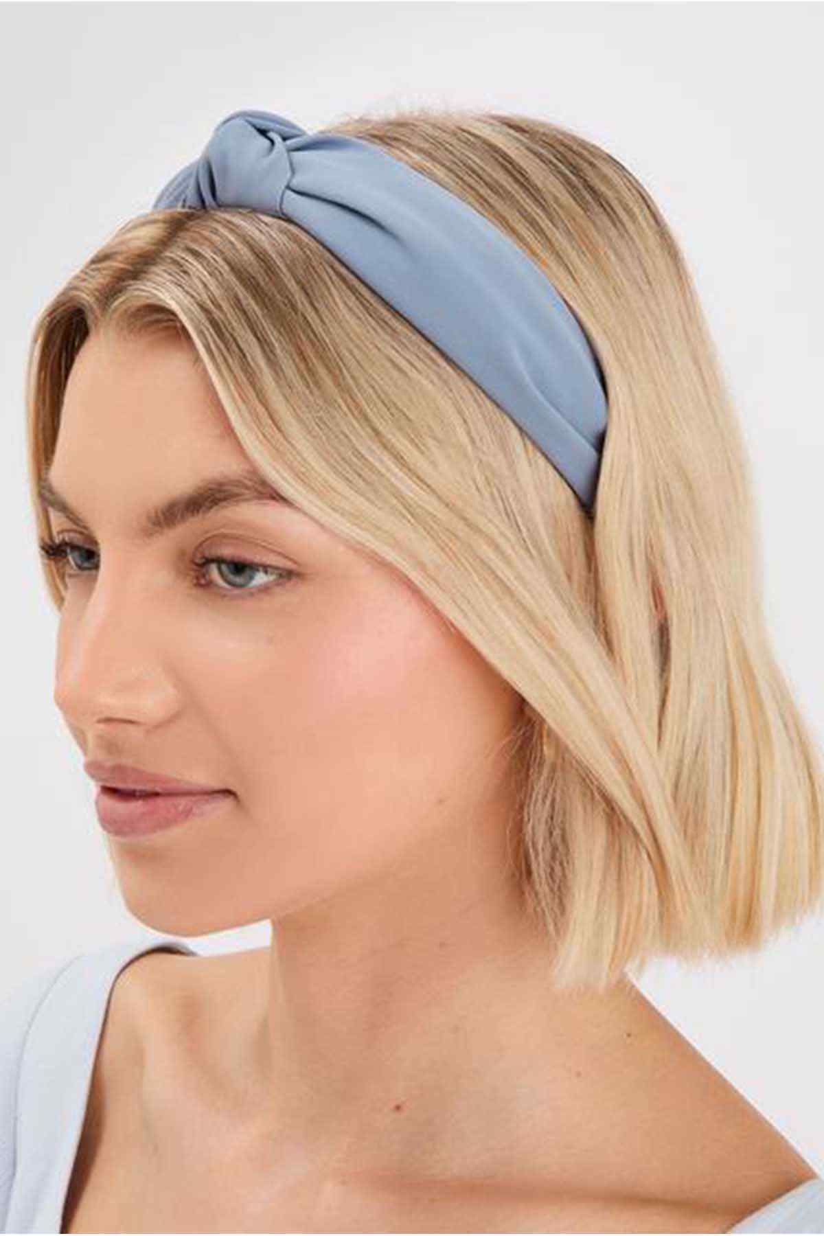 Blue fabric headband with gathered knot front, worn on short blonde hair