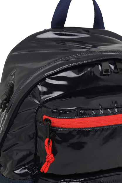 Glossy mini backpack side with red zipper pull and dangling cord detail