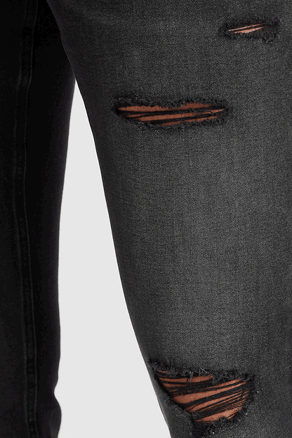Black denim jeans close-up of orange-brown distressed rip details