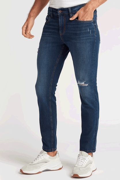 Men's blue denim jeans with distressed knee panels and cuffed hem