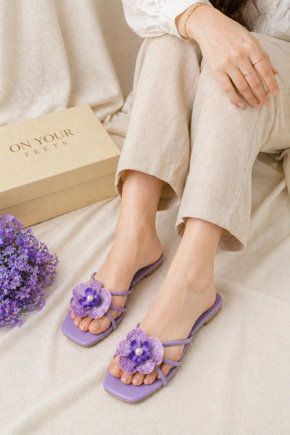 Purple flat sandals with purple flower appliques and slingback straps