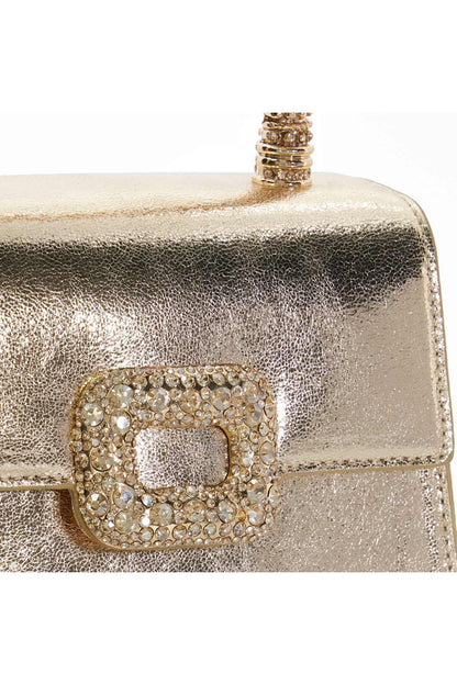 Gold mini handbag close-up of rhinestone front clasp and textured metallic finish