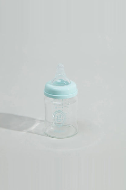 Baby bottle with blue cap and clear body, viewed from front
