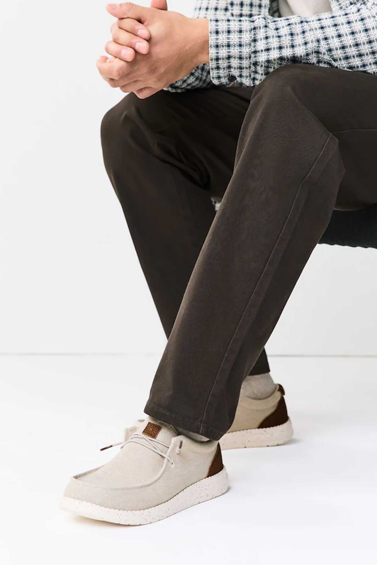 Dark pants with beige lace-up sneakers, low profile and textured sole