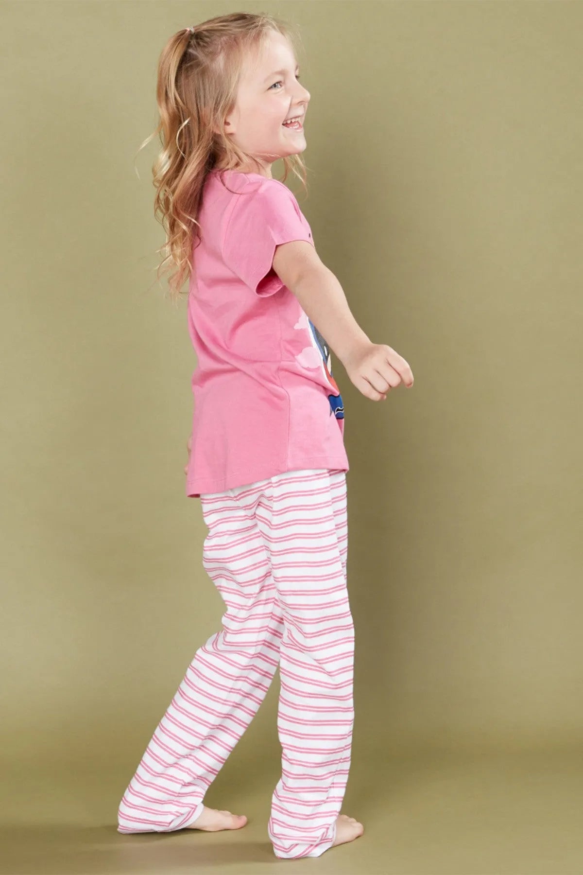 Kids pink pajama set, side view: graphic T-shirt with striped pants