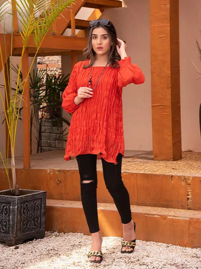 Red long-sleeve tunic with ruffled hem and gathered detailing, worn with black leggings