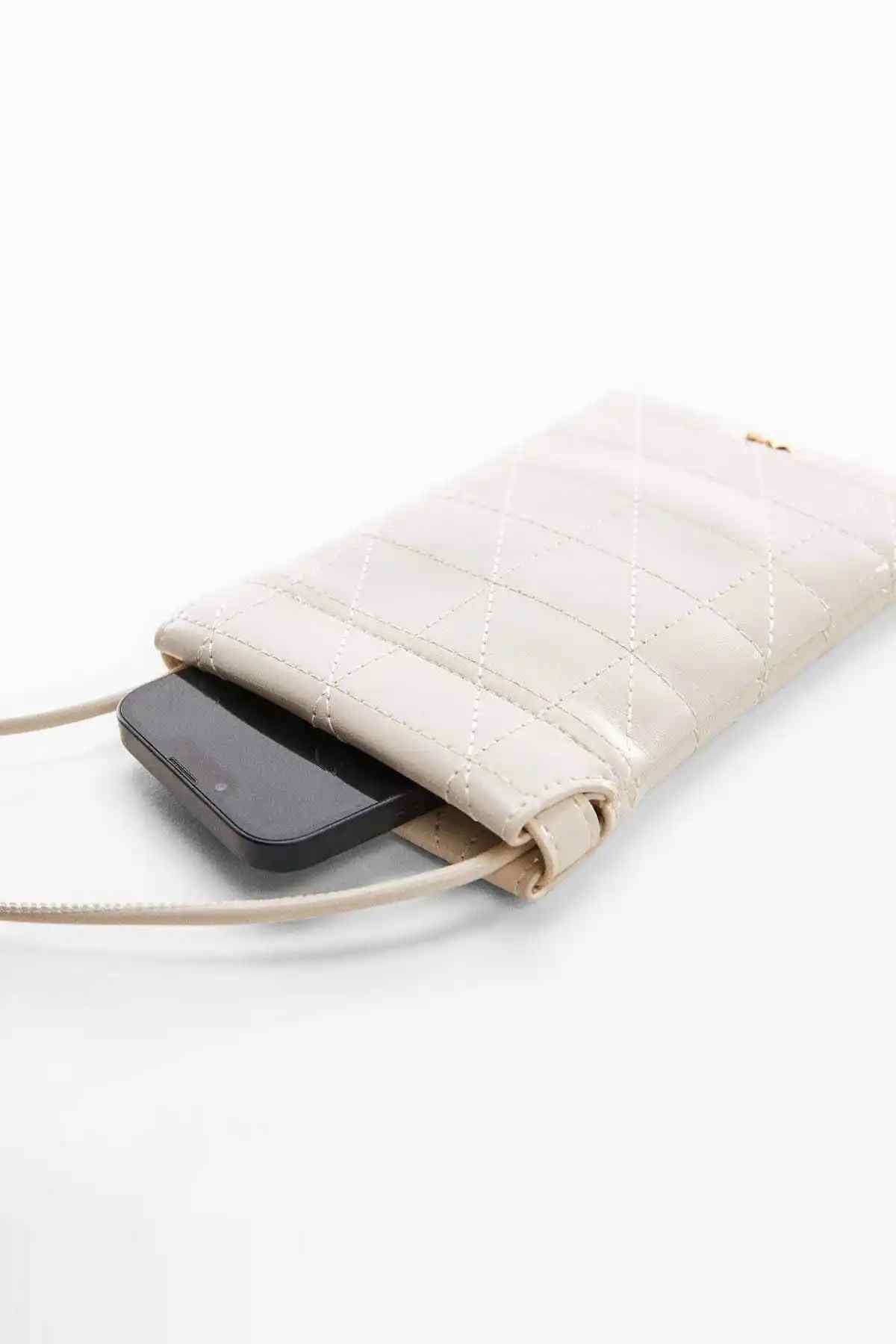 Off-white quilted crossbody bag with opening, showing a smartphone inside