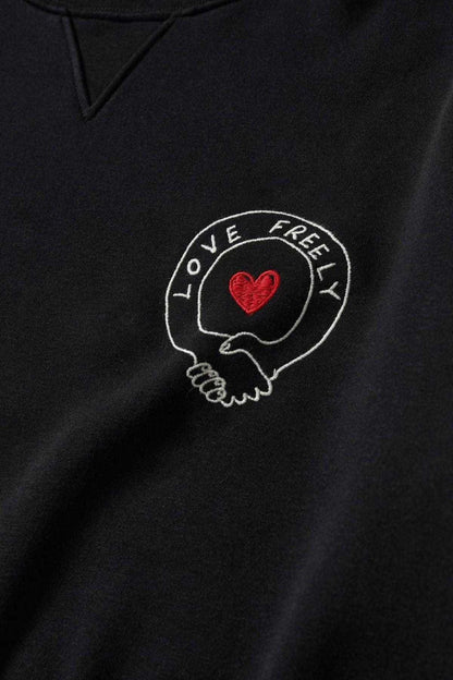 Black sweatshirt with circular red heart logo embroidery on chest