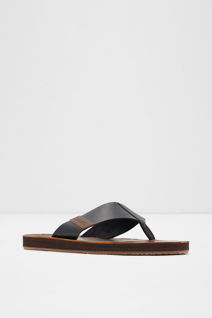 ALDO black slide sandals with wide strap and brown sole, angled view