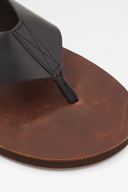 ALDO close-up of black thong strap on brown leather slide sandal sole