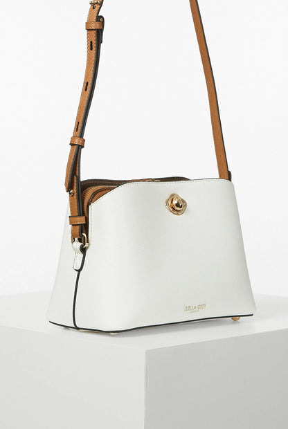White crossbody handbag with tan shoulder strap and gold top clasp