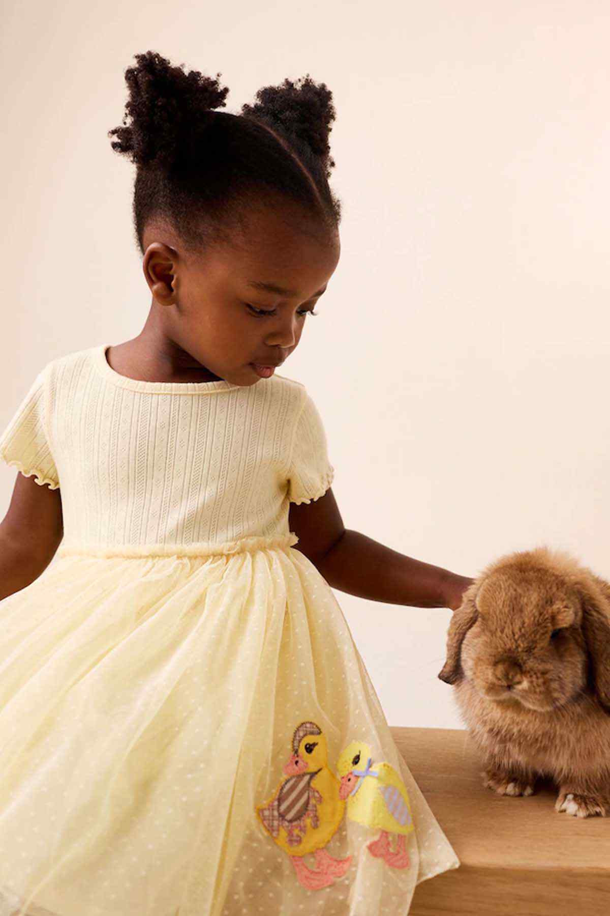Girls' pale yellow dress with large bunny and chick graphic on skirt