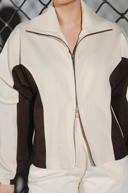 Beige zip-front jacket with dark brown sleeve panels and stand collar