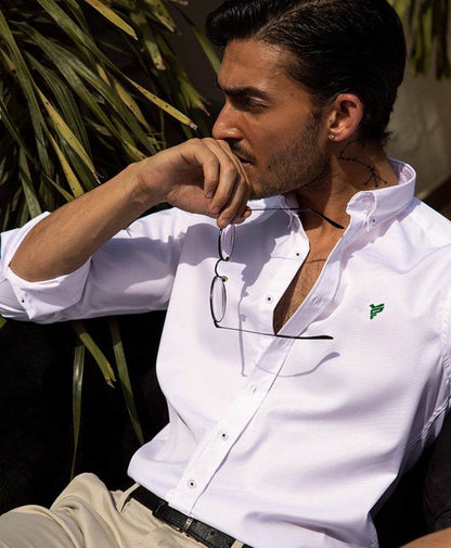 White slim-fit button-up shirt with open collar, green logo, and visible front buttons