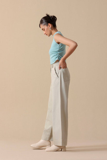 Mint sleeveless crop top with light beige wide-leg trousers, back view