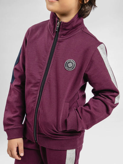 Burgundy zip-up kids tracksuit jacket with chest badge and dark side stripes
