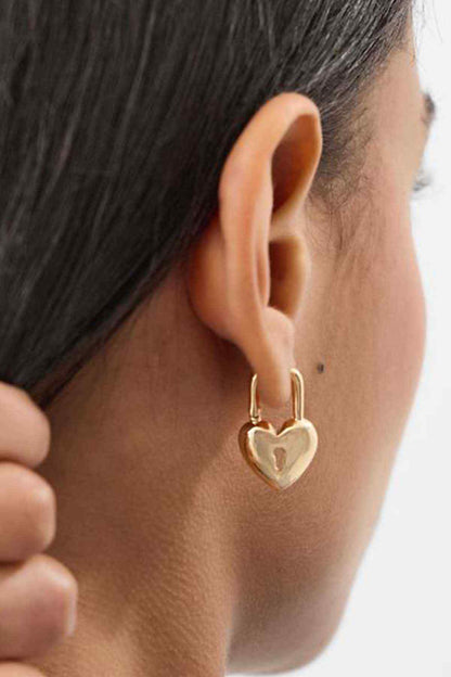Gold heart drop hoop earrings on ear, small open-heart charm