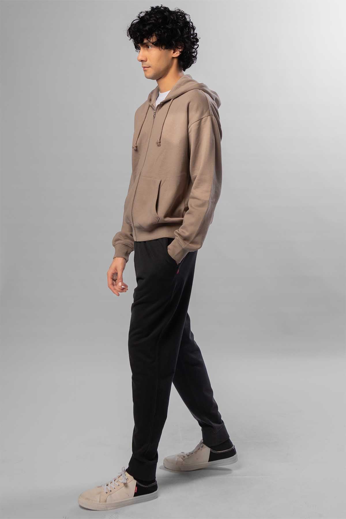 Men's taupe zip-front hoodie and black jogger pants, side view