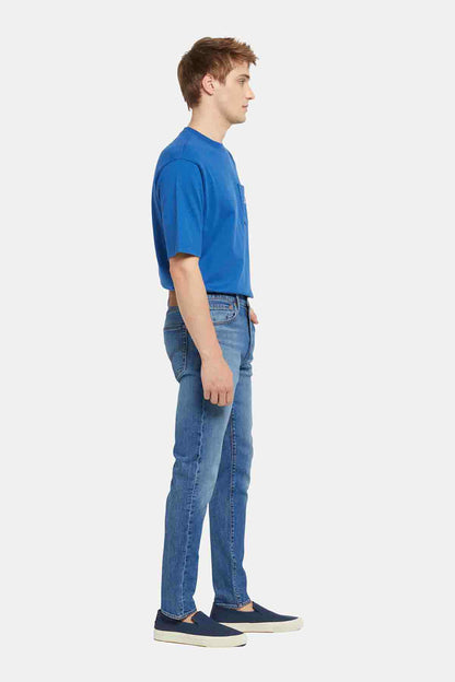 Blue crewneck T-shirt and blue jeans, side view, small chest logo