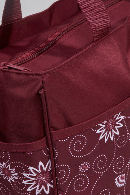 Burgundy tote bag close-up: zipper, inner pocket, and floral patterned panel