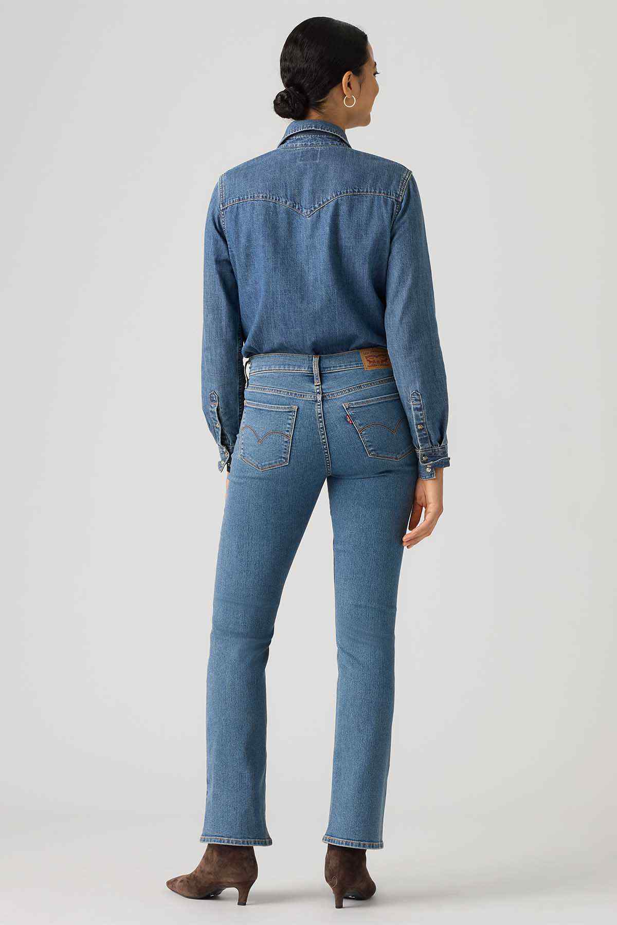 Women's medium-wash denim jeans, back view with yoke, belt loops, and bootcut hem