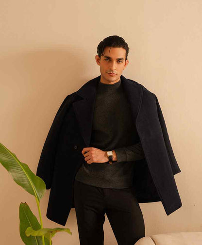 Dark fitted overcoat worn open, with notched lapels and button front; long sleeves.