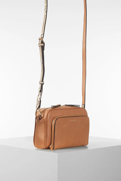 Brown leather mini crossbody bag with adjustable strap and small front pocket