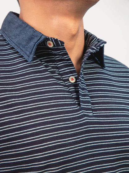 Dark blue striped polo shirt close-up, button placket with red accents and collar
