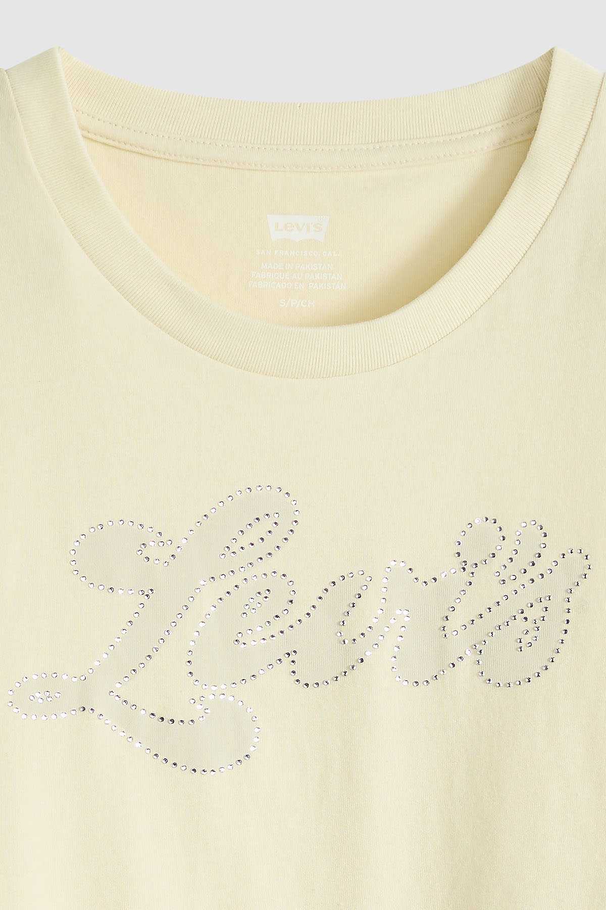 Levi's T-shirt close-up, pale yellow crew neck with rhinestone script logo