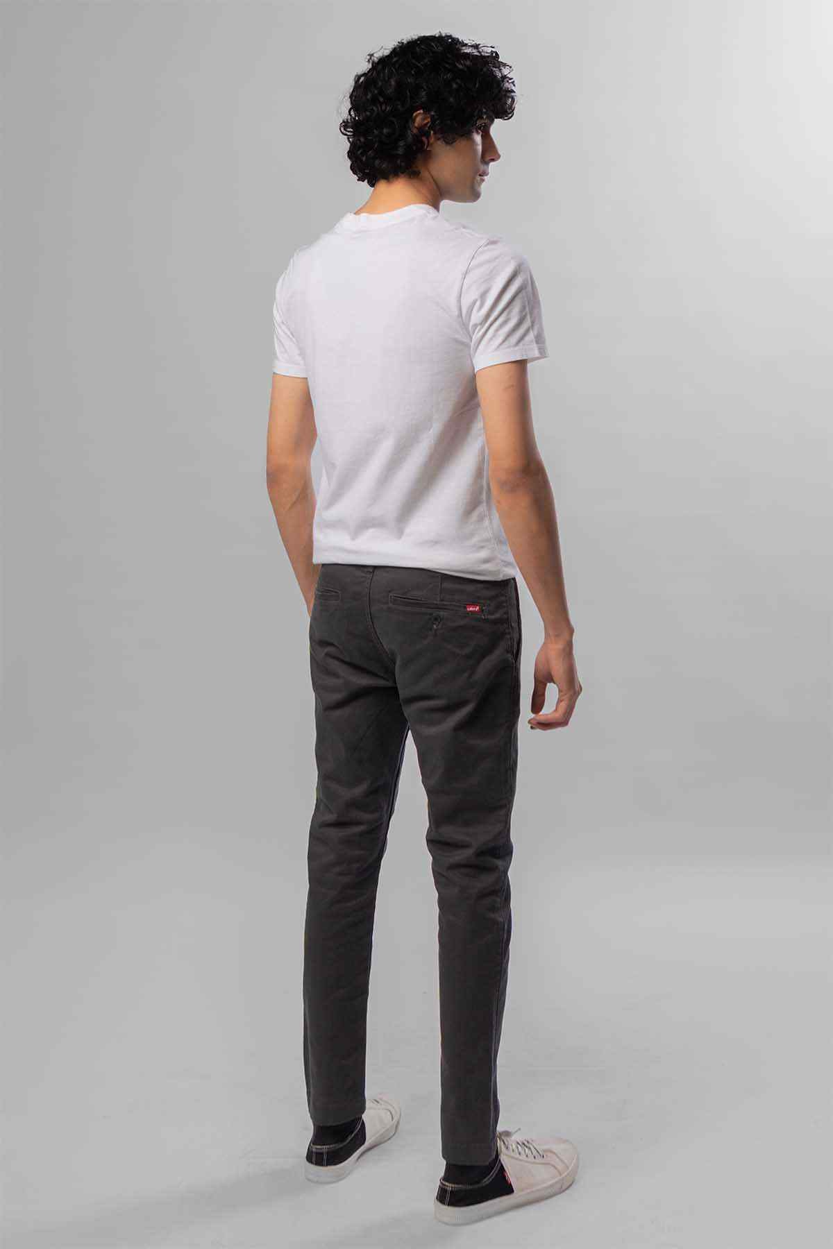 Men's dark grey jeans from the back, worn with a white T-shirt