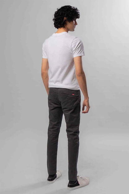 Men's dark grey jeans from the back, worn with a white T-shirt