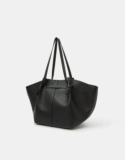 Black tote bag with top handles, curved sides, and gold clasp detail