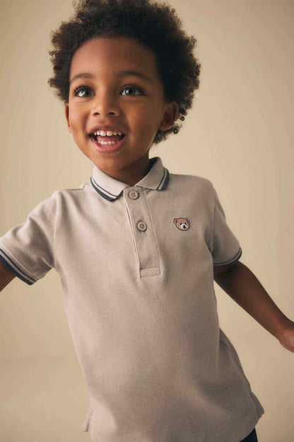 Kids stone polo shirt with navy striped collar, small chest bear patch