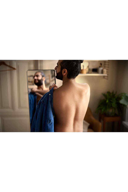 Back view of person using an electric shaver at neckline