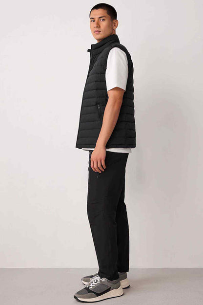 Black quilted puffer gilet sleeveless with high neck and black straight-leg trousers