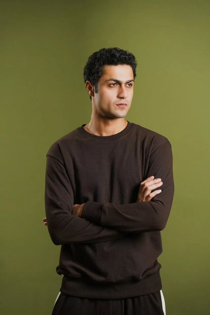 Dark brown knit sweatshirt with long sleeves and crew neck, worn by a man