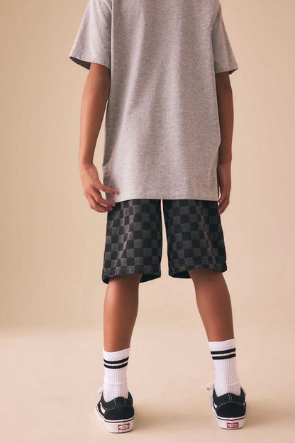 Grey T-shirt back view with logo, paired with black check shorts
