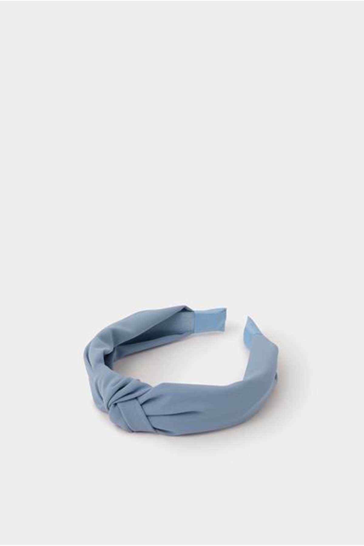 Blue fabric knotted headband, laid flat with twist detail at the top